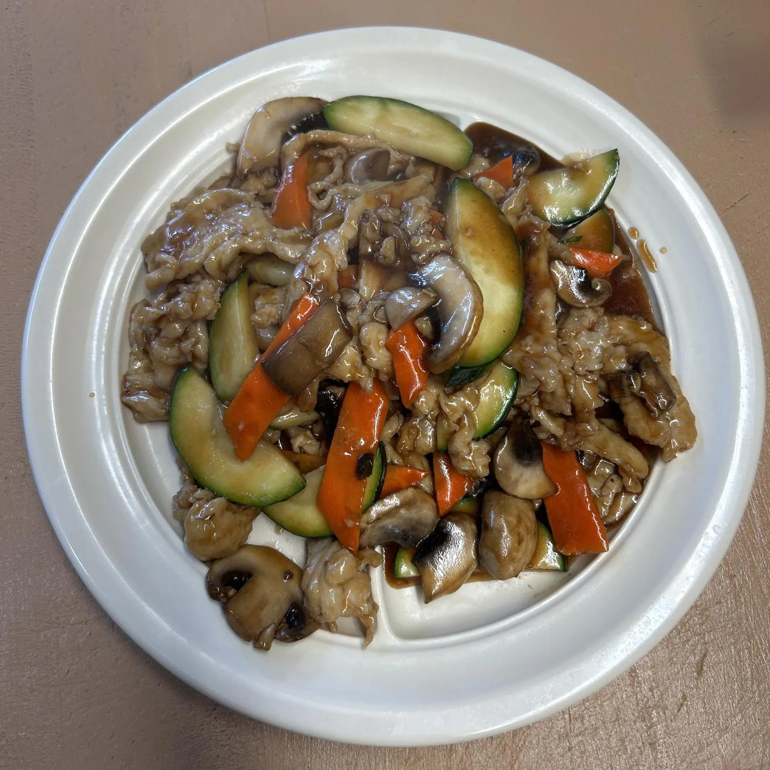 Pork with Mixed Vegetables presents sliced pork stir - fried with a mix of vegetables including mushrooms, zucchinis, and carrots, all coated in a savory sauce at Asian Wok, a Chinese restaurant in Port Lavaca