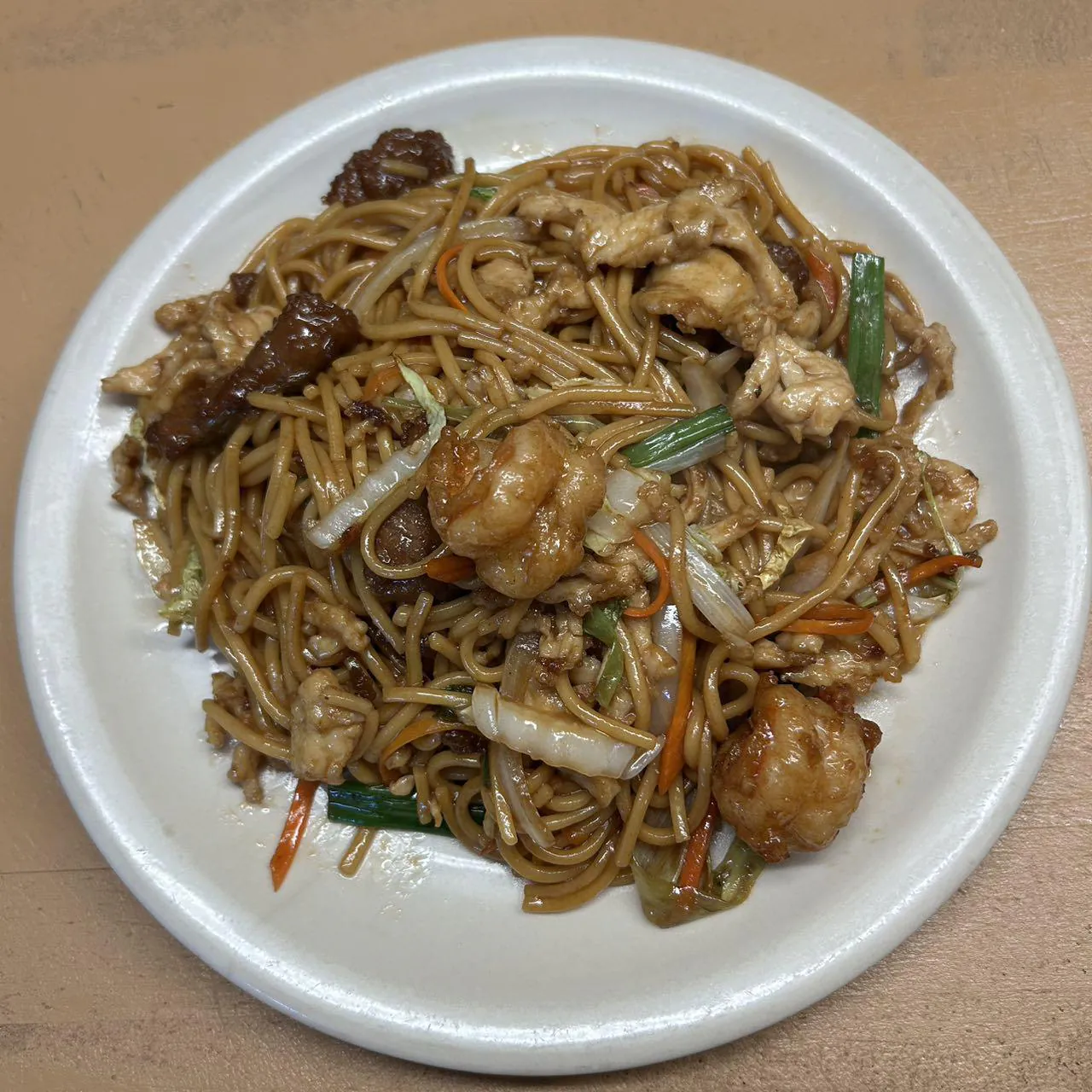 Combination Chow Mein features stir - fried noodles with a combination of vegetables like scallions, bean sprouts, carrots, and pieces of chicken and shrimp, all coated in a savory sauce at Asian Wok, a Chinese restaurant in Port Lavaca