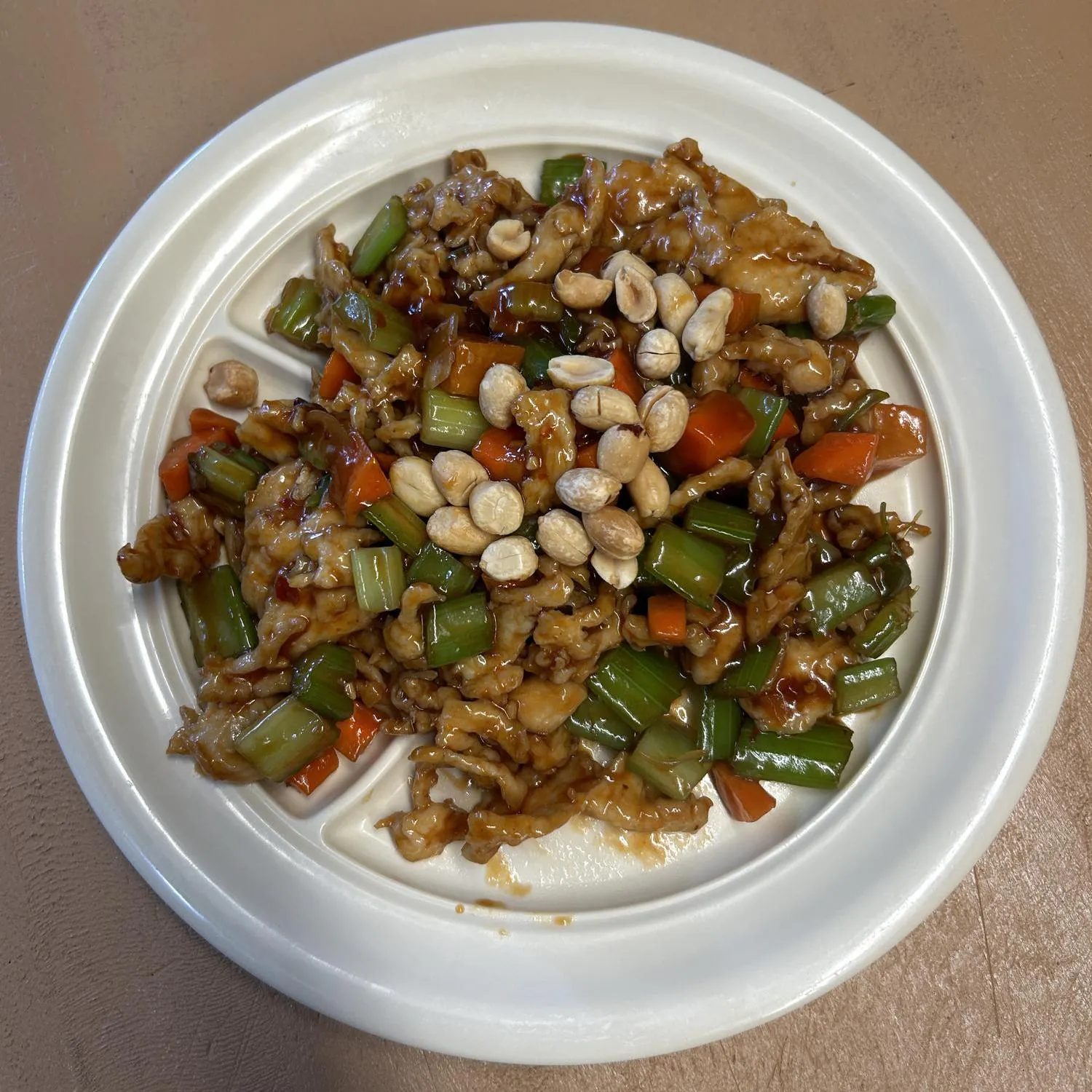 Kung Pao Chicken features diced chicken stir - fried with celery, carrots, and peanuts, all coated in a savory sauce at Asian Wok, a Chinese restaurant in Port Lavaca