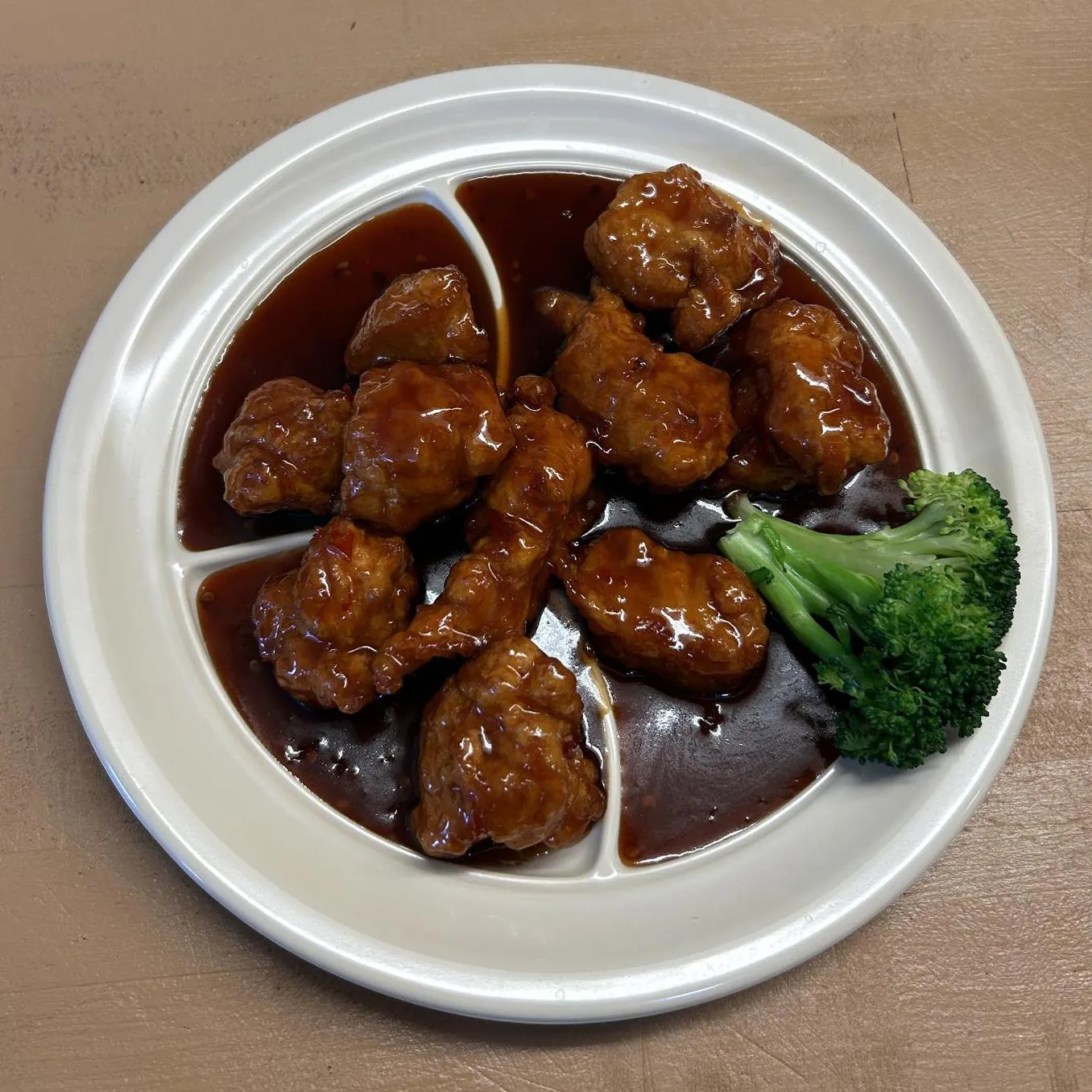 General Tso's Chicken shows crispy chicken pieces coated in a savory sauce at Asian wok, a Chinese restaurant in Port Lavaca