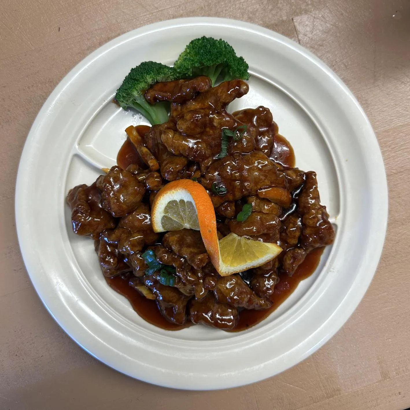 Orange Beef features tender beef slices coated in an orange - flavored sauce, garnished with orange slices and broccoli at Asian wok, a Chinese restaurant in Port Lavaca
